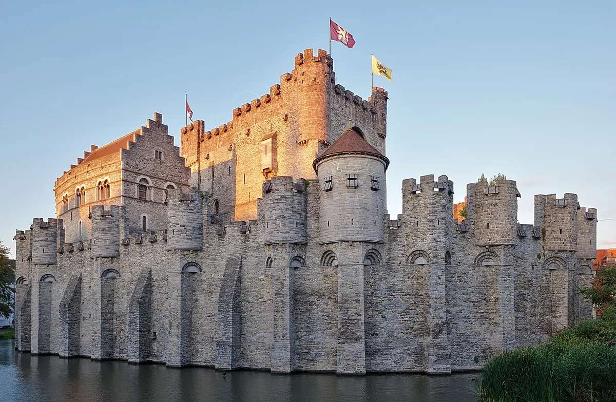 Het middeleeuwse Gravensteen kasteel in Gent weerspiegeld in het water van de Leie