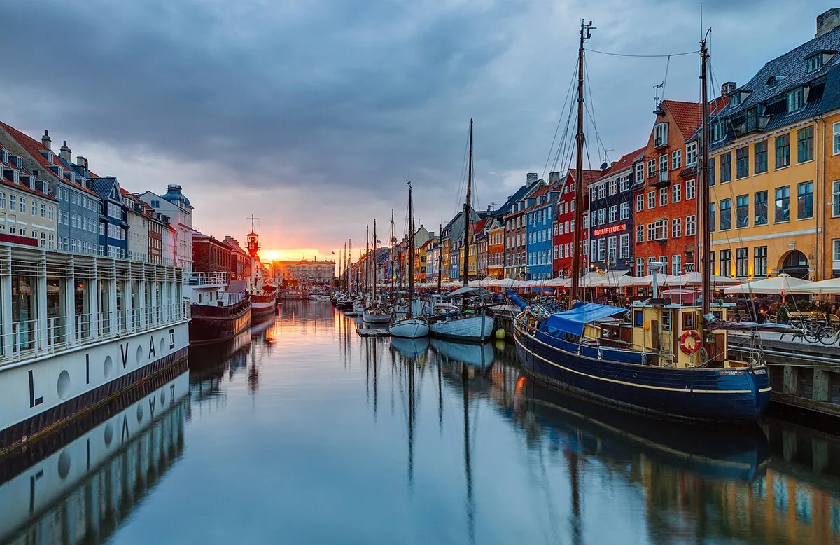 De kleurrijke gevels langs Nyhavn in Kopenhagen weerspiegeld in het kanaalwater