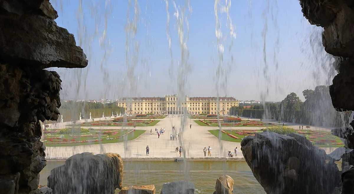 Het paleis Schoenbrunn in Wenen gezien vanuit de tuinen met de Neptunusfontein op de voorgrond